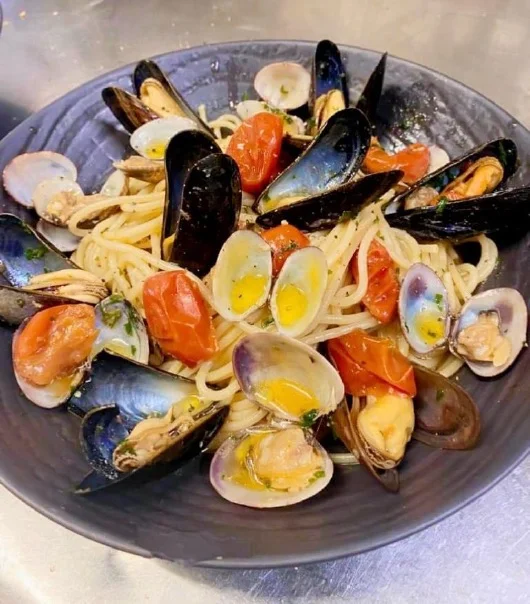 Linguine met mosselen en vongole in een donkere kom